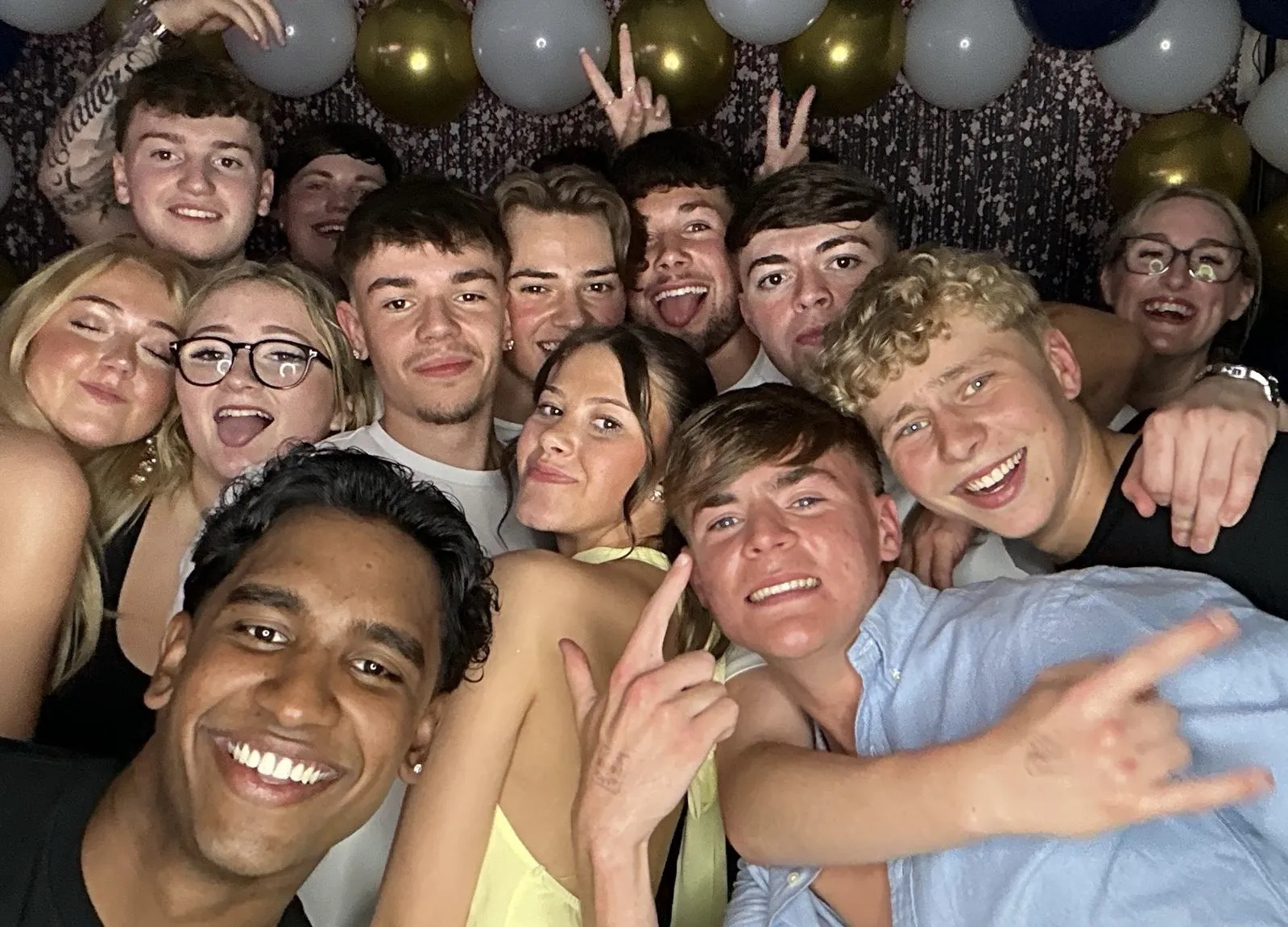 Big group squeezed into the photo booth under the balloons