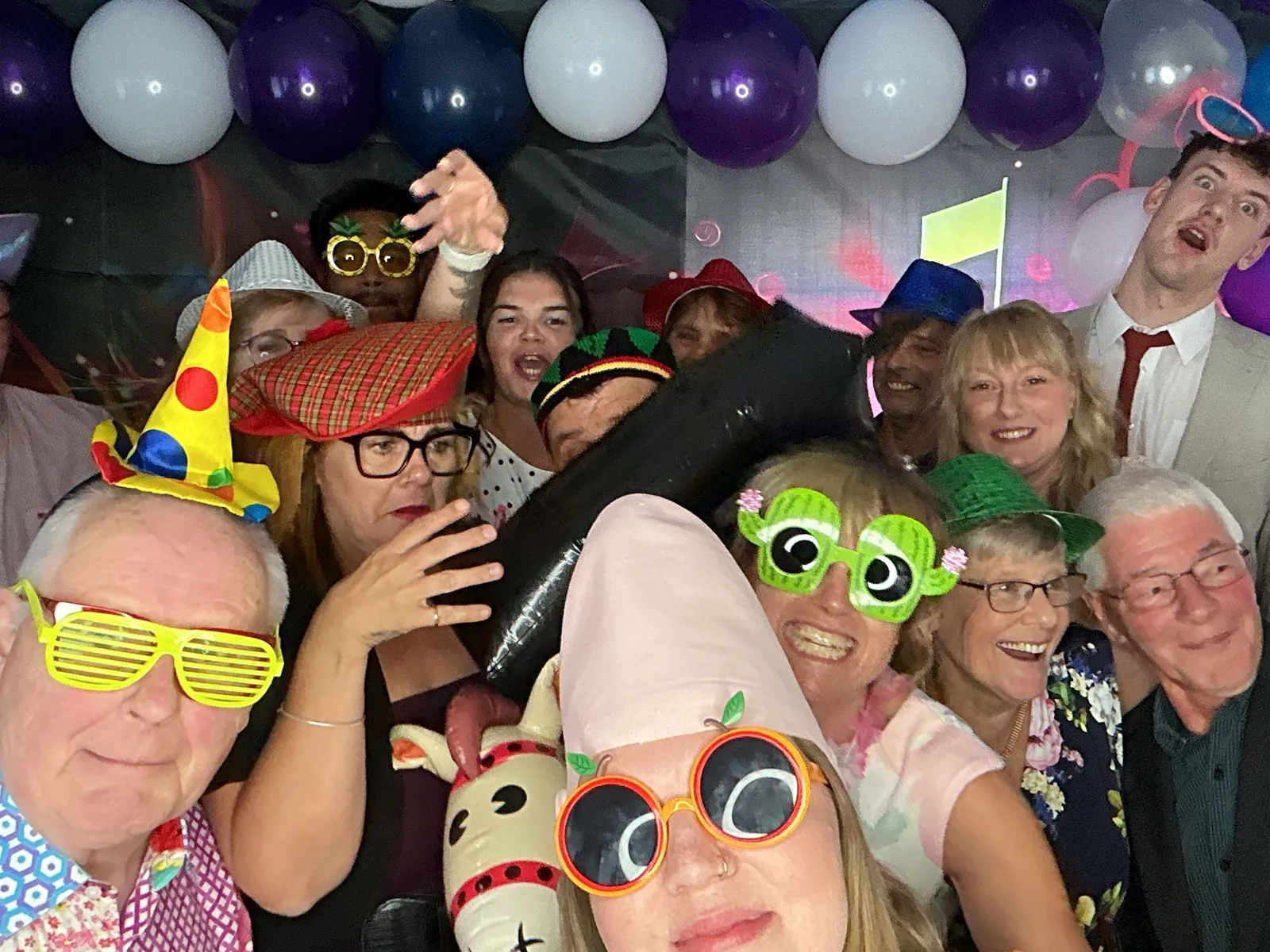Huge group of guests crammed in with props and balloons