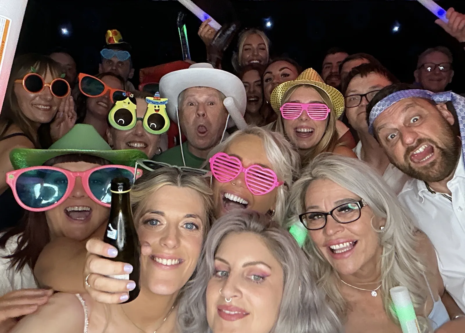 Guests in oversized glasses and hats mid-party